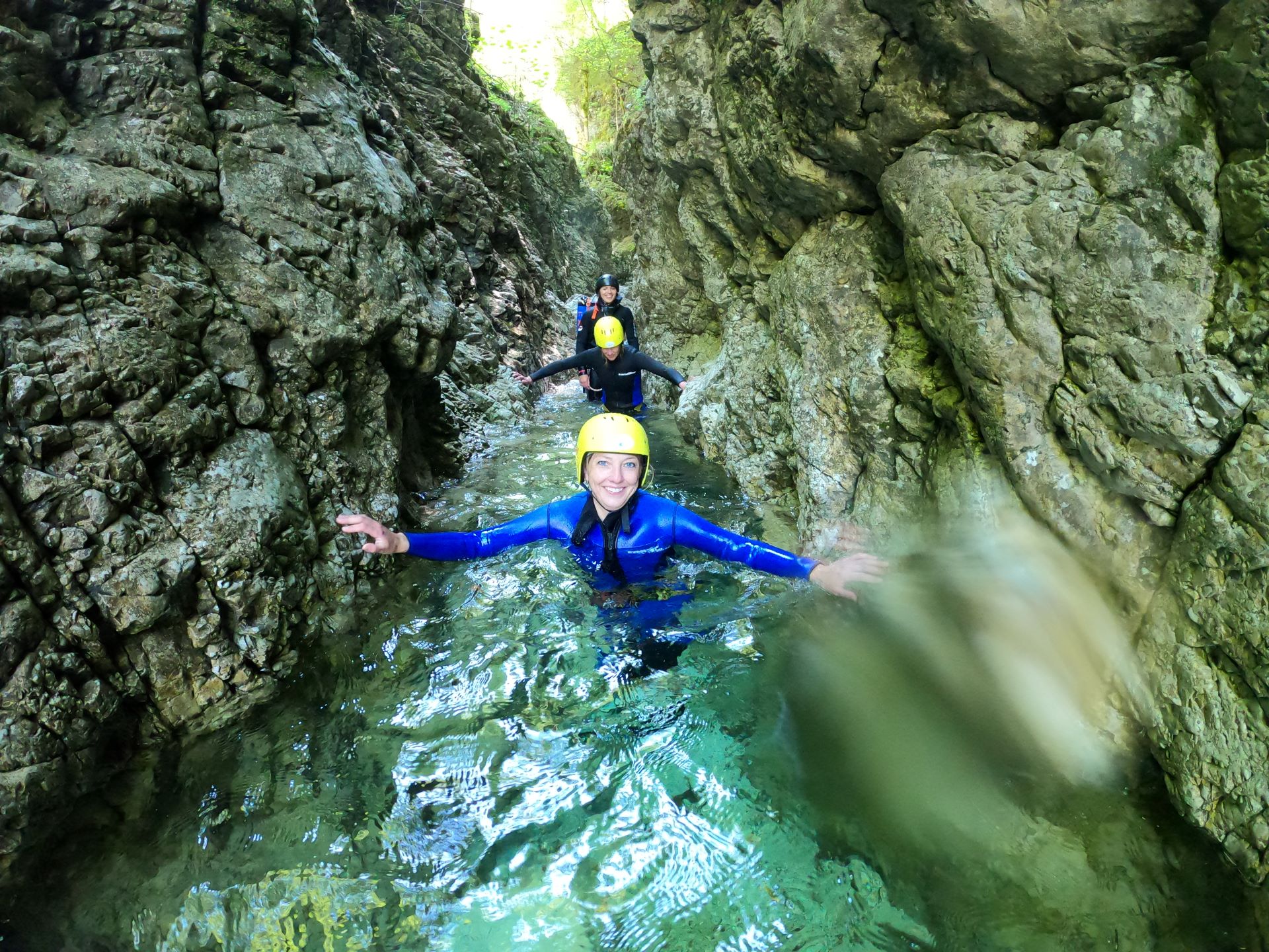 person abseiling next to a waterfall during a canyoning adventure in the Soča Valley