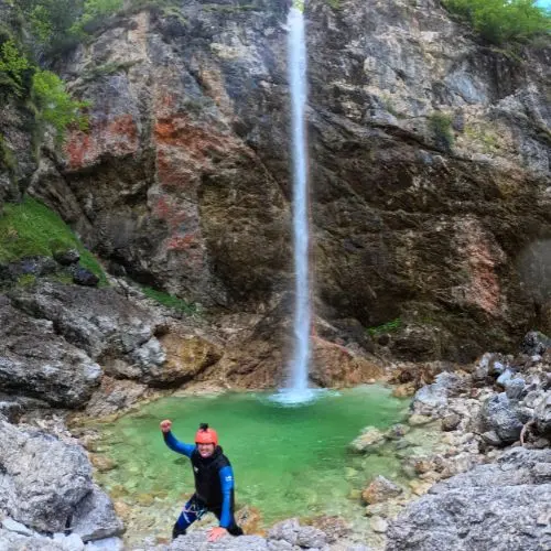 A thrilled guest celebrating after a 50-meter rope descent down the iconic Parabola waterfall in Fratarica.