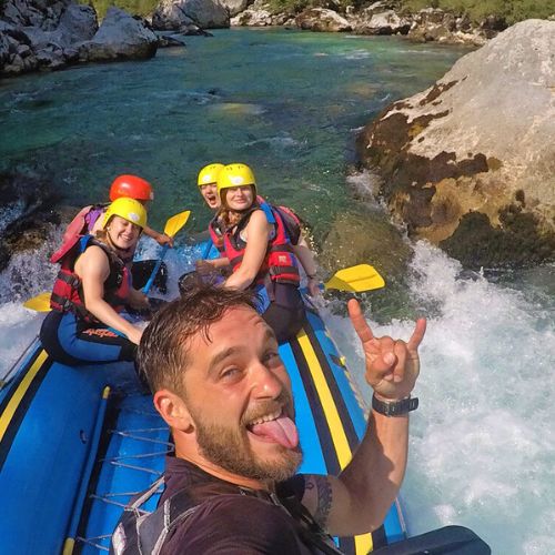 Happy bachelorette party group and their guide taking a selfie during a rafting trip on the Soča River in Bovec, Slovenia.
