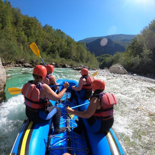Group of women enjoying rafting on the emerald Soča river for a bachelorette party in Bovec, Slovenia.